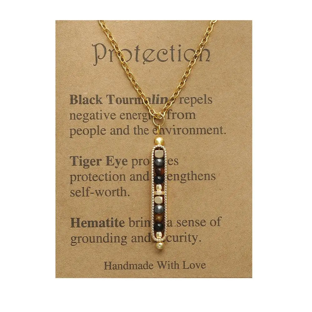 Handmade gold necklace featuring black tourmaline, tiger eye, and hematite on a protective card.